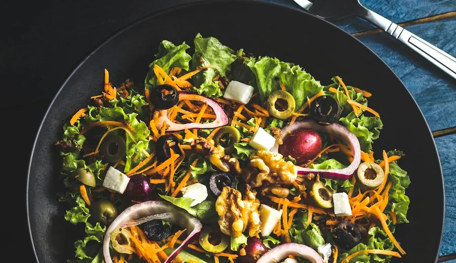 Large volume vegetable salad with crisp cucumbers, cherry tomatoes, and baby greens